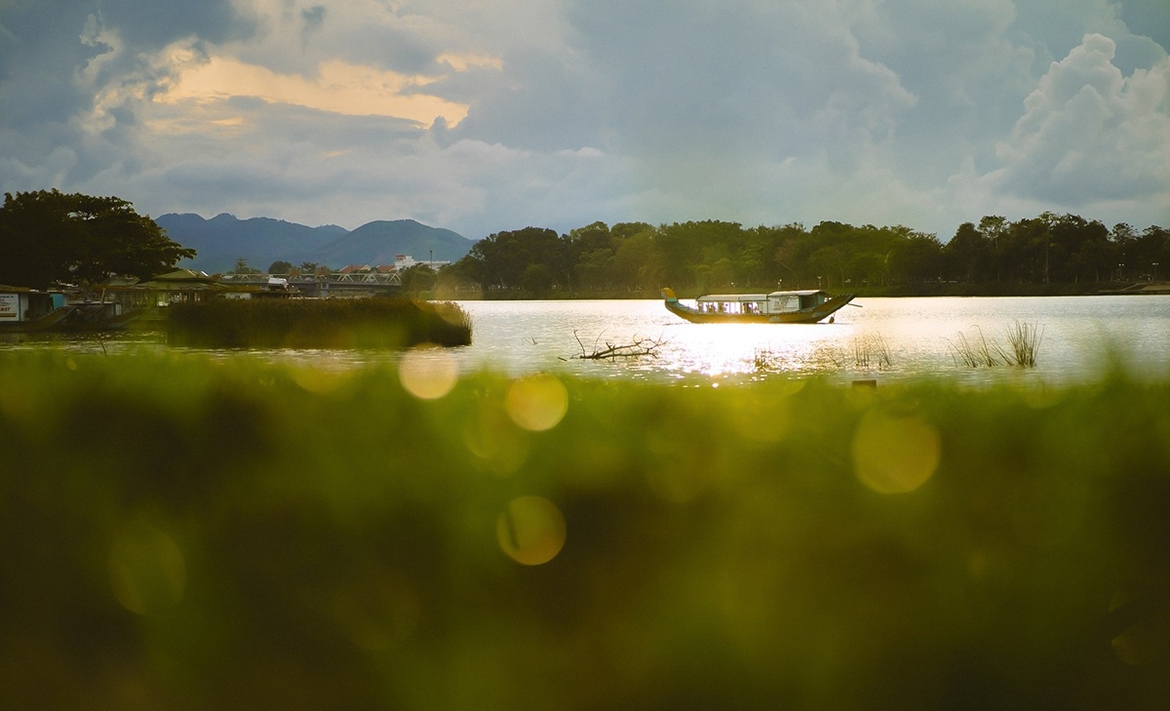 Thuyền lướt trên sông Hương êm đềm, gần cầu Dã Viên, nối cồn Dã Viên với bờ nam sông Hương. Còn được gọi là cầu đường bộ Bạch Hổ, cầu có 4 làn xe và 2 lề đường cho người đi bộ, trở thành địa điểm thư giãn, hóng gió lý tưởng cho người dân, du khách.